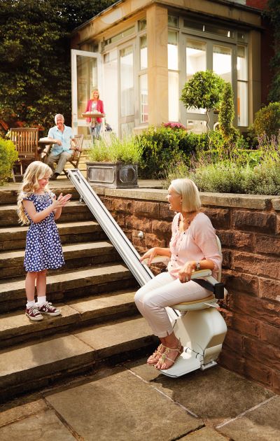 Woman enjoying the out doors with her stairlift from acorn stairlifts